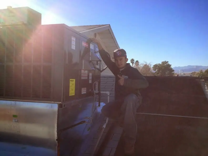 HVAC technician performing Air Duct Cleaning on a rooftop unit in Newberry